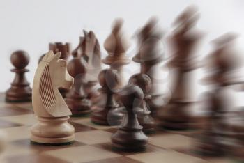 White knight facing black chess pieces