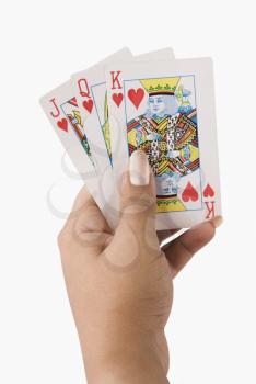 Close-up of a woman's hand holding playing cards