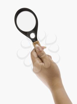 Close-up of a woman' hand holding a magnifying glass