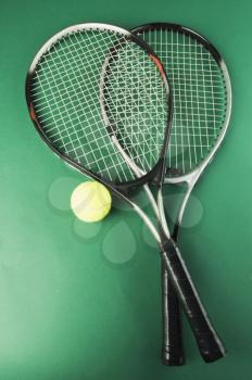 Close-up of two tennis rackets with a tennis ball