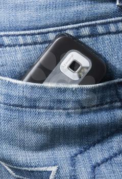 Close-up of a mobile phone in a jeans pocket