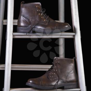 Close-up of leather boots on a step ladder