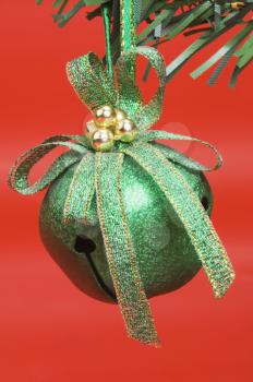 Green Christmas bell hanging on a Christmas tree