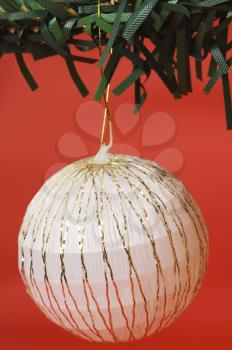 White bauble hanging on a Christmas tree