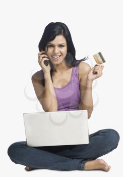Woman shopping online and talking on a mobile phone
