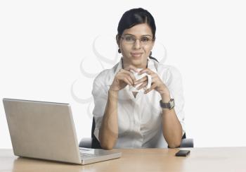Businesswoman in front of a laptop and drinking coffee