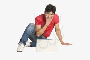 Man looking at a laptop with shocked expressions