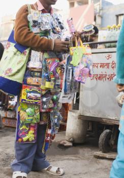 Vendor selling toys in a street market, New Delhi, India
