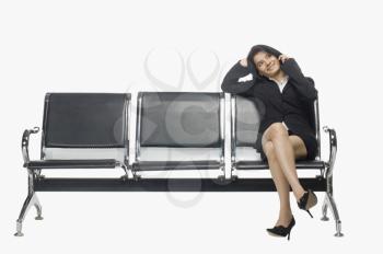 Businesswoman sitting on an armchair and talking on a mobile phone