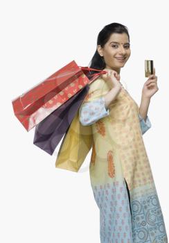 Young woman holding shopping bags and showing a credit card