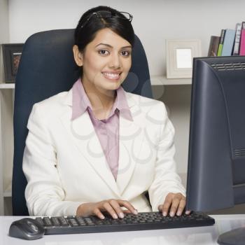 Portrait of a businesswoman working on a desktop PC in an office