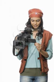 Female videographer looking at video camera
