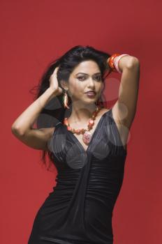 Portrait of a female fashion model posing against red background