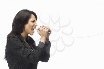 Businesswoman shouting in a tin can phone