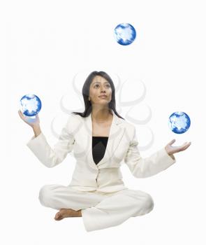 Businesswoman juggling globes