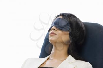Businesswoman wearing eye mask and sleeping