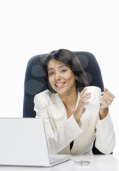Businesswoman holding a coffee mug and smiling