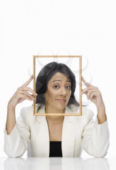 Businesswoman looking through a picture frame