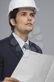 Close-up of a young male architect holding a paper