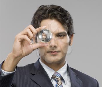 Close-up of a businessman looking at a crystal ball