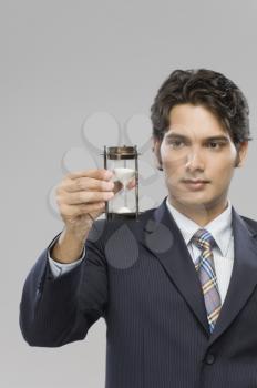 Close-up of a businessman looking at an hourglass