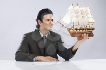 Businessman looking at a sailing ship