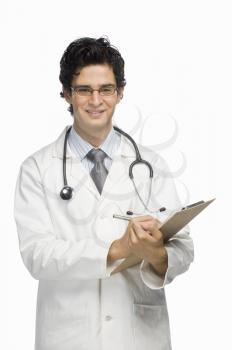 Portrait of a male doctor writing on a clipboard