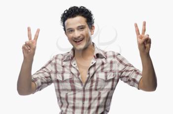 Portrait of a man gesturing victory sign