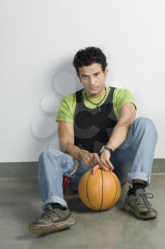 Portrait of a man sitting with a basketball