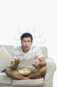 Man watching television and looking surprised