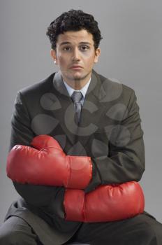 Bruised businessman wearing boxing gloves