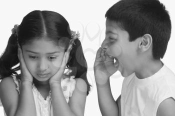 Girl covering her ears while her brother shouting