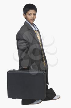 Portrait of a  boy wearing oversized suit and holding briefcase