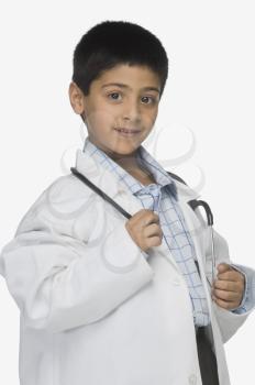 Portrait of a boy wearing lab coat and holding a stethoscope