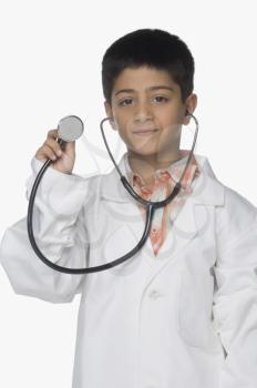 Portrait of a boy wearing lab coat and showing a stethoscope