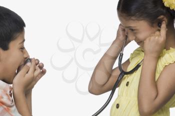 Boy speaking into stethoscope and a girl listening
