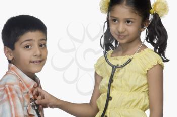 Girl examining a boy with a stethoscope