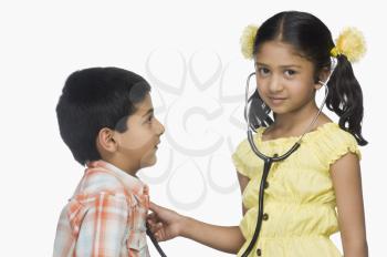 Portrait of a girl examining a boy with a stethoscope