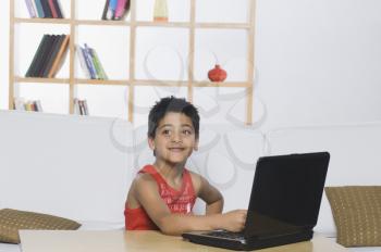 Boy working on a laptop and smiling