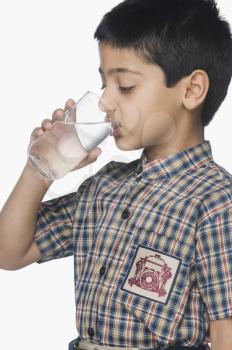 Schoolboy drinking a glass of water