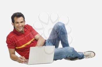 Portrait of a man using a laptop and smiling