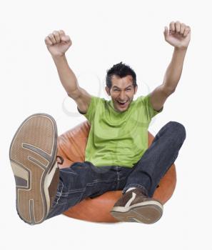 Portrait of a man cheering on a bean bag