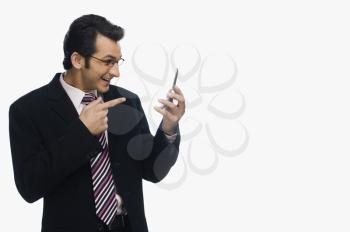 Businessman pointing at a mobile phone and smiling