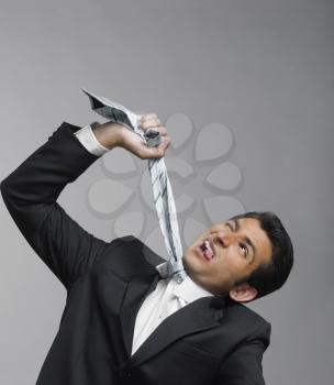 Close-up of a businessman strangling himself with necktie