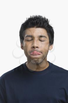 Close-up of a man licking his lips with eyes closed