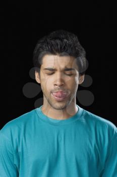 Man sticking his tongue out with his eyes closed