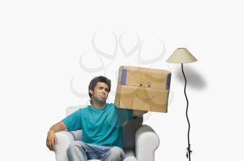 Man holding a cardboard box and making a face