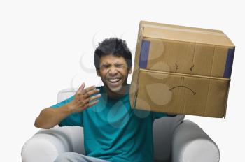 Man holding a cardboard box with a smiley face and laughing