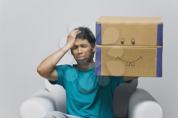 Man holding a cardboard box and looking sad