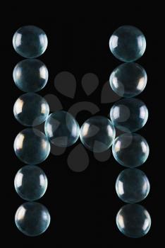 Close-up of marble balls arranged in the shape of letter H
